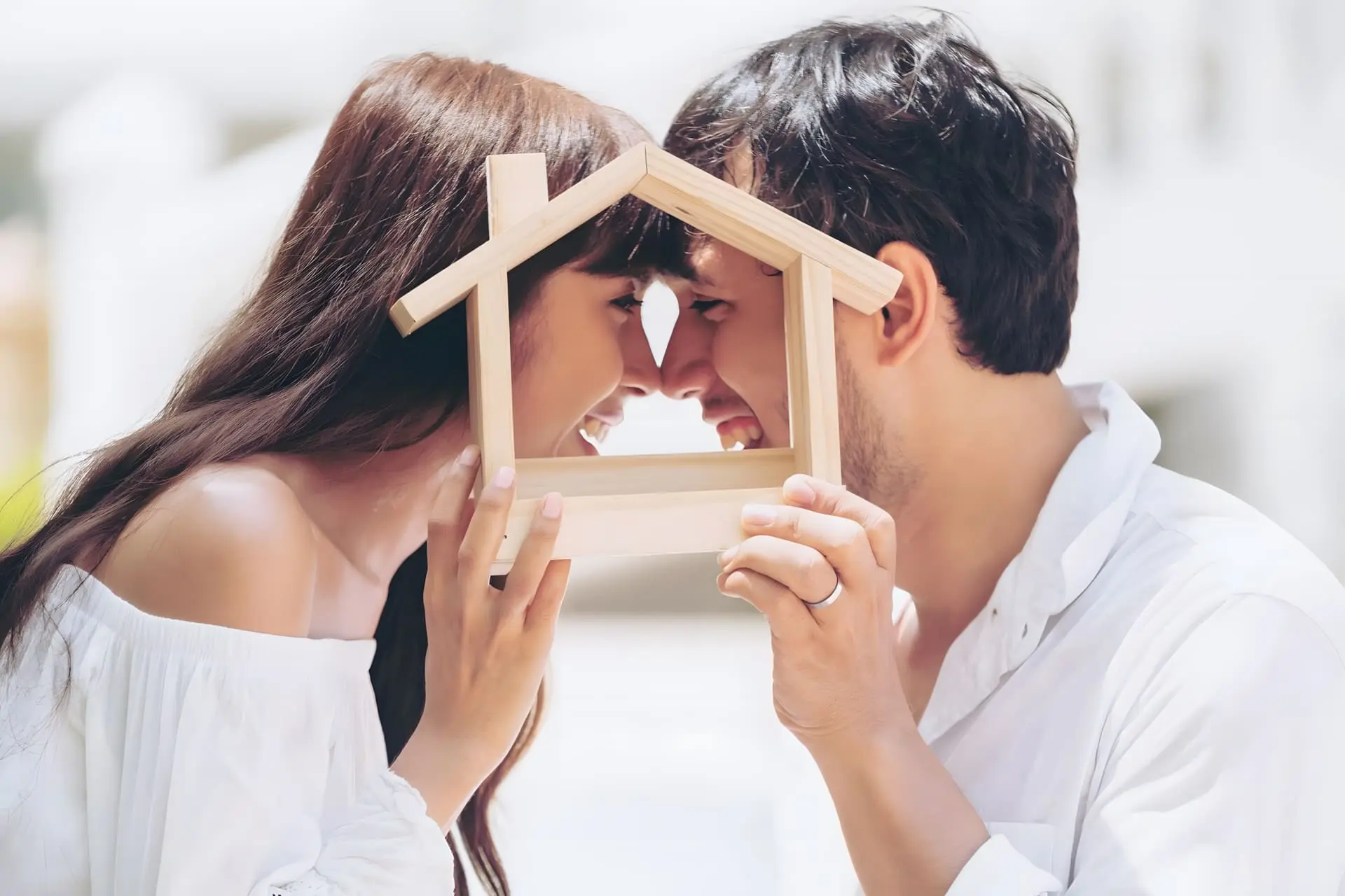 Happy Couple Holding a wooden house